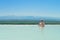 Young man sitting in thermal pool with mountain view