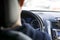 a young man is sitting at the wheel of a car, rear view of the dashboard