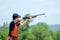 Young man skeet shooting with airborne shell