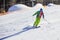 Young man skiing downhill on winter resort