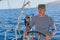 Young man skipper at the helm sail boat