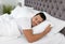 Young man sleeping in bed with soft pillows