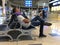 A young man is sleeping on a chair at the airport, putting a pillow under his head