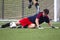 A young man slide kicks a soccer ball