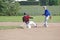 A young man sliding into second base