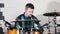 Young man in small headphones playing drums