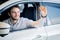 Young man smiling and cheering in his car