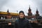 Young man smilling with Oberbaum Bridge and yellow train on background in cloudy weather in Berlin. Travel and tourism in Berlin