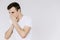 A young man sneezes into a napkin. Isolated white background