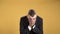 Young man sneezing on yellow background. Portrait of sneezing man.