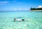 Young man snorkeling next to tropical island