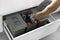 A young man sorts garbage in containers in the kitchen in slow motion. Modern kitchen with a system for sorting waste