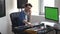 Young man in sound recording studio. Guy sit in front keyboard and talking on phone. Adjusting music console during