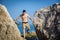 Young Man Spanning Gap Between Coastal Boulders