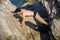 Young Man Spanning Gap Between Coastal Boulders