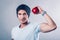 Young man sports appearance shows muscles and holds apples in his hands