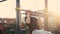 A young man in sportswear pulls himself up on a horizontal bar at a city sports ground.