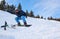 Young man in sportswear snowboarding over pine trees background