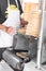 A young man is stacking fresh corn tortillas from the gas stove conveyor belt