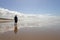 A young man standing alone on a smooth beach at Witsand, South Africa