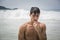 Young man standing on beach by the ocean