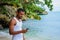 Young man standing at beach with phone in hand staring at phone screen