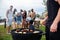 Young man standing and cooking sauseges on barbeque party