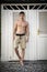 Young Man Standing in Doorway of Rustic Beach Hut