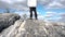 Young man standing on edge of cliff enjoying scenery. Footage. View of man from back on top of cliff. Person engaged in