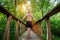 Young man standing on a footbridge in the forest.