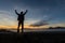 Young man standing on an old wall under glorious evening sky