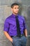 Young man standing outdoors by wall in New York City, relaxing, thinking