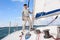 Young man standing on a sailboat. Summer vacations, cruise, recreation, sport, regatta