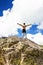 Young man standing on top of a cliff with arms raised