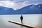 Young man stands alone on the jetty in the tegernsee lake