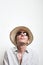 Young man in straw hat and sunglasses look up