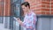 Young man, student , designer using tablet computer, Outdoor Standing by Wall