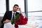 young man in suit with bouquet of red roses waiting for girlfriend