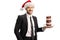 Young man in a suit holding a plate of chocolate donuts and wearing a Santa Claus hat