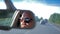 Young man in sunglasses is driving a car. Reflection face in rearview mirror of vehicle.