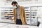 Young man in the supermarket in the department with frozen foods. A brunette in a medical mask during the coronavirus pandemic.