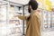 Young man in the supermarket in the department with frozen foods. A brunette in a medical mask during the coronavirus pandemic