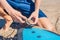 Young man surfer getting on the surfboard`s leash