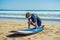 Young man surfer training before go to lineup on a sand beach. L