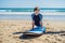 Young man surfer training before go to lineup on a sand beach. L