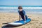 Young man surfer training before go to lineup on a sand beach. Learning to surf. Vacation concept. Summer holidays