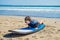 Young man surfer training before go to lineup on a sand beach. Learning to surf. Vacation concept. Summer holidays