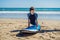 Young man surfer training before go to lineup on a sand beach. Learning to surf. Vacation concept. Summer holidays