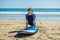 Young man surfer training before go to lineup on a sand beach. Learning to surf. Vacation concept. Summer holidays