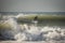 Young man surfing epic wave his body is out of focus the foreground